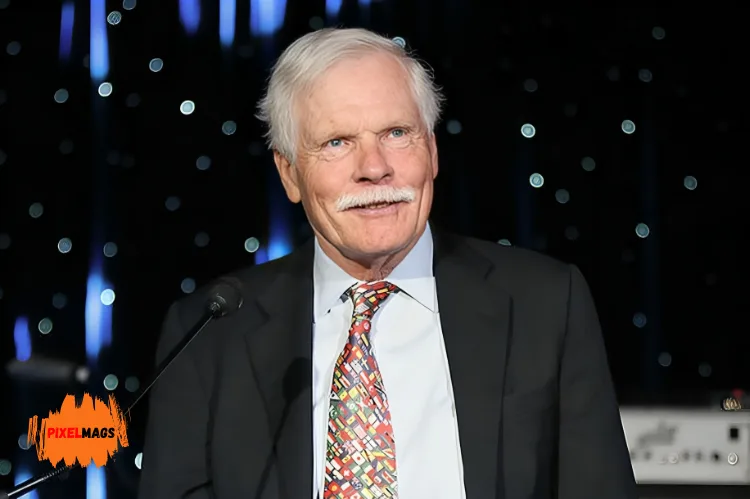 Ted Turner standing at a podium and speaking into a microphone.