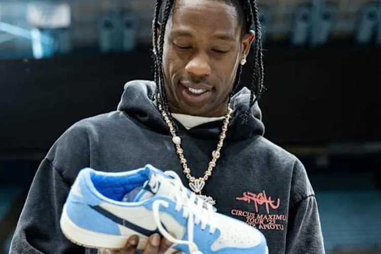 A sleek product-focused shot showing Travis Scott standing.