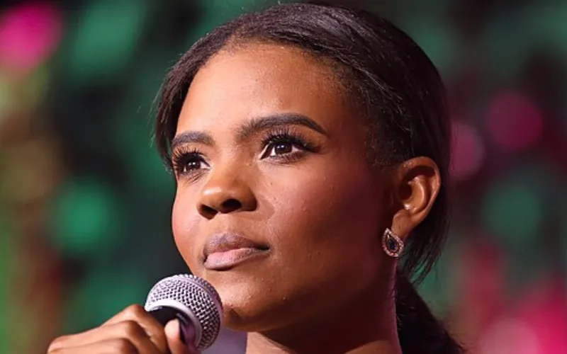 Candace Owens speaking into a microphone during a public event, close-up portrait with colorful blurred background