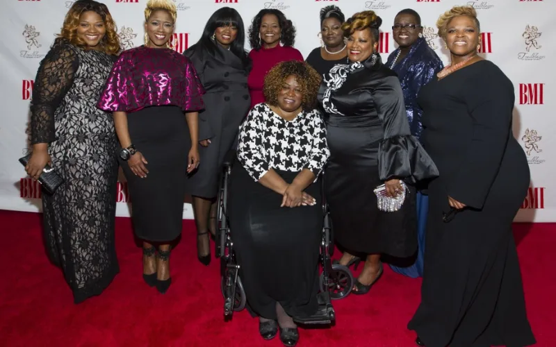 The Pace Sisters pose together on the red carpet at a BMI event, dressed in elegant formal gowns and smiling for the camera.